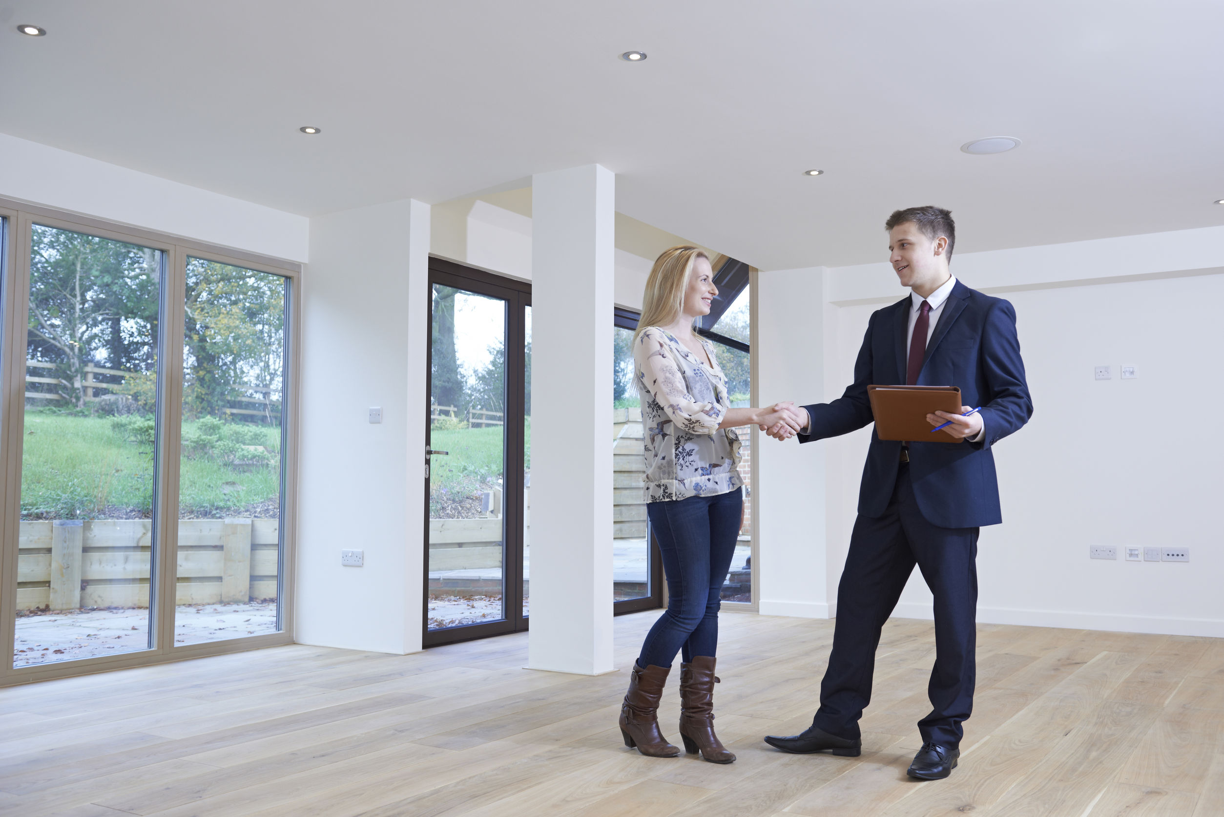 woman shaking hands with estate agent in new home